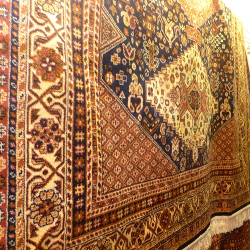 A Caucasian design rug the blue field with triple central medallions and extensive beige and gold