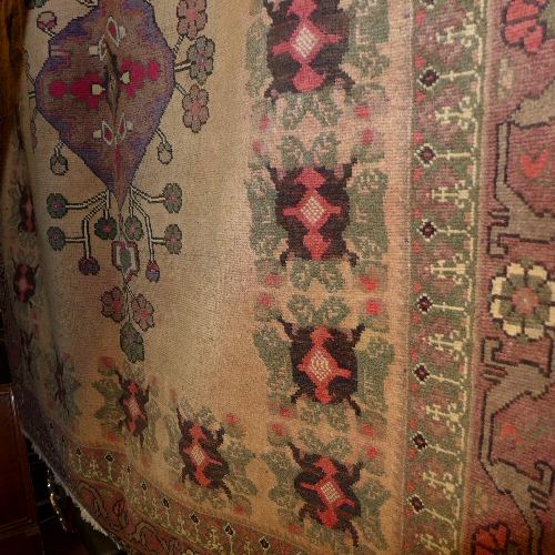 A Persian hand knotted Heriz carpet the fawn ground with central flowerhead medallion in a green