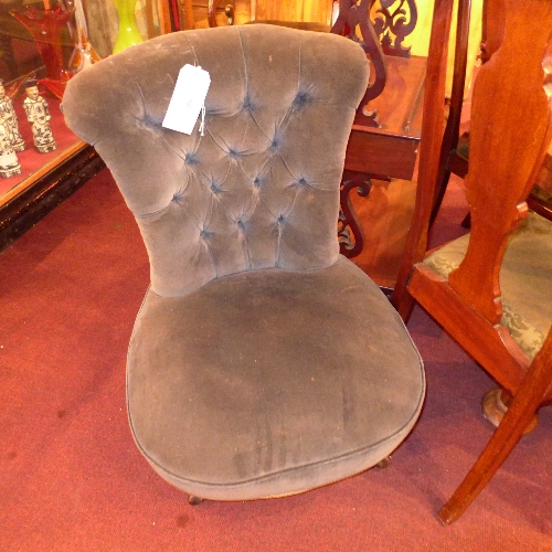 A Victorian mahogany nursing chair upholstered in blue velour raised on carved supports