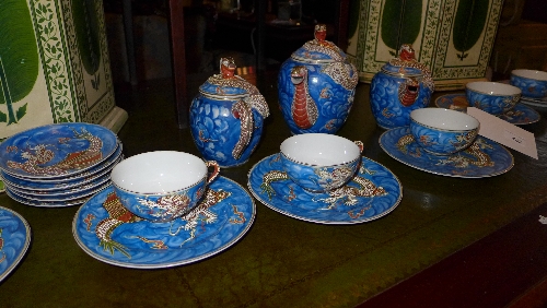 A Japanese eggshell porcelain tea set decorated with dragons on a blue ground