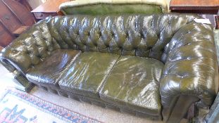 A Chesterfield sofa three seat buttoned green leather with squab cushions and raised on bun feet W