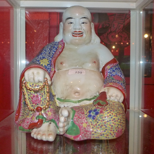 A Chinese porcelain model of a laughing Buddha