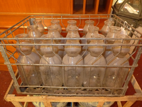 Thirty old glass milk bottles in two crates