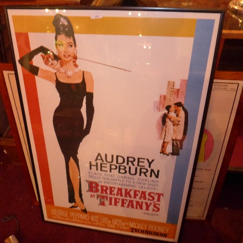 A framed print of a Audrey Hepburn in Breakfast in Tiffany`s film poster in a black frame