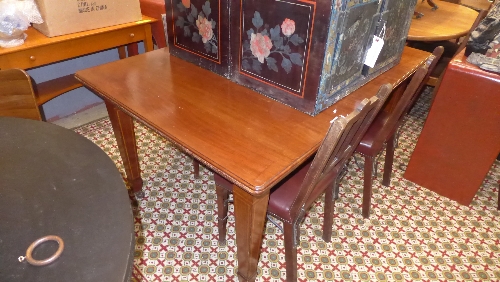 An Edwardian extending dining table with extra leaf raised on tapered support having retailer