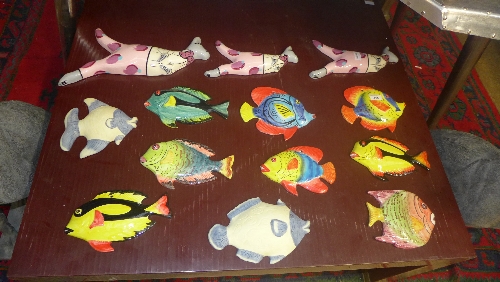 A collection of coloured wall plaques fish, parrots and others