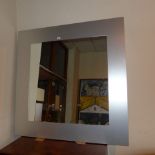 A contemporary wall mirror the square plate within steel frame