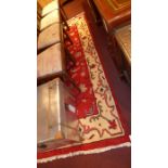 A handmade Persian rug with a red field surrounded by a frieze border 267 cm x 154 cm