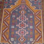 A hand knotted Persian prayer rug the blue ground with central motif in triple border