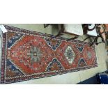 A hand knotted Bokhara rug the terracott