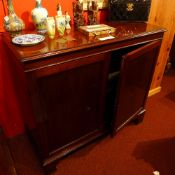 A George III mahogany side cabinet the two panel doors enclosing shelved interior on bracket feet