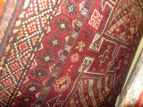 A fine old North East Persian Kurdi Keleh rug with triple pole medallion on a rouge field within