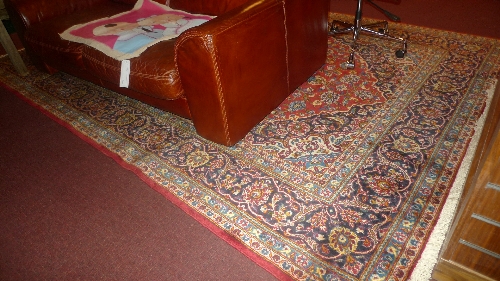 A fine Central Persian Kashan carpet with pendant medallion on a rouge field within stylized