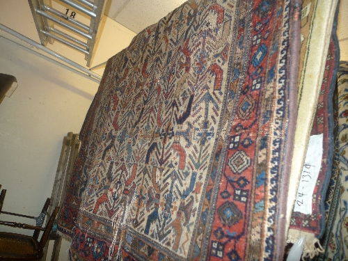 An antique Persian prayer rug the camel coloured field with stylized motifs within a similar