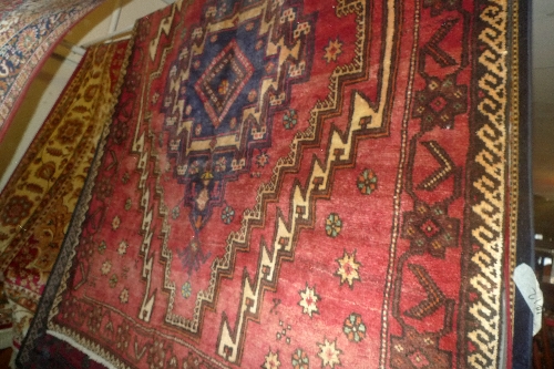 A fine North East Persian Meshad Belouch rug with multi pole medallion on a terracotta field L 250