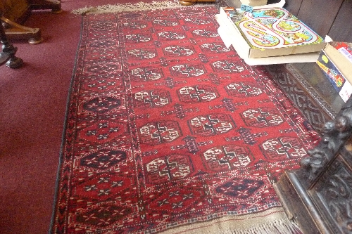 An antique Persian Bokhara rug the red field with repeated motifs within a similar border L 160 x