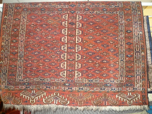An antique Persian Bokhara rug the red field with repeated diamond motifs within a stylized border L