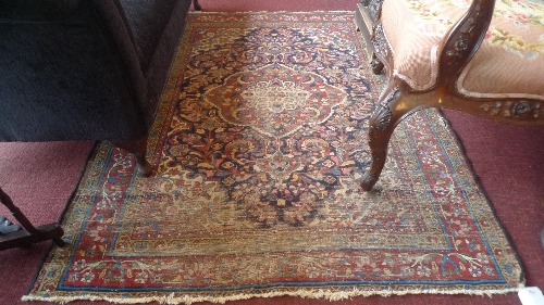 An antique Persian rug the red and navy blue field with central pendant encompassed by geometric