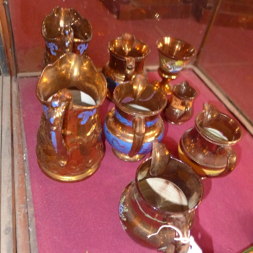 A collection of copper lustre graduated form jugs H 10-27 cm
