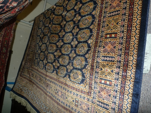 A Persian style Bokhara rug the blue field with repeated motifs within a geometric border L 1.90 x W