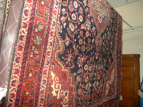 A fine North West Persian Sarouk rug with central pendant medallion on a sapphire field stylized