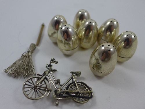 A set of eight silver egg form cruets, two 800 silver napkin rings, a miniature bike and other items