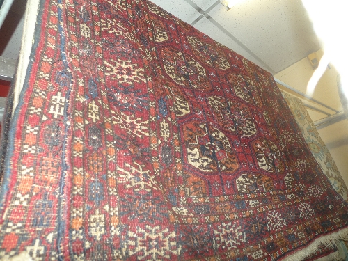 An antique Persian Bokhara rug the red field with repeated motifs within a multi border L 150 x w 90