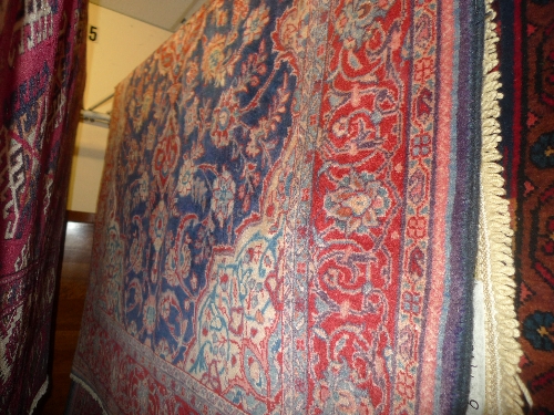 A fine North West Persian Sarouk rug with central terracotta medallion on a sapphire field with