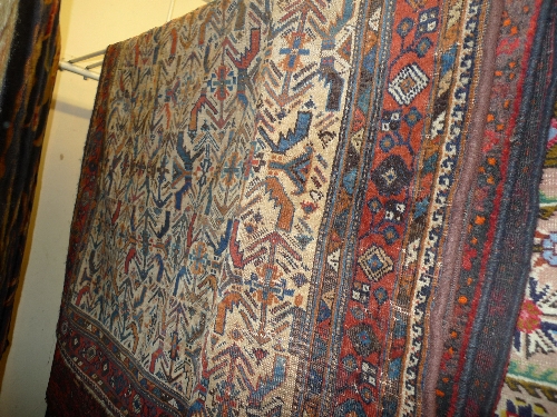 An antique Persian prayer rug the camel coloured field with stylized motifs within a similar border