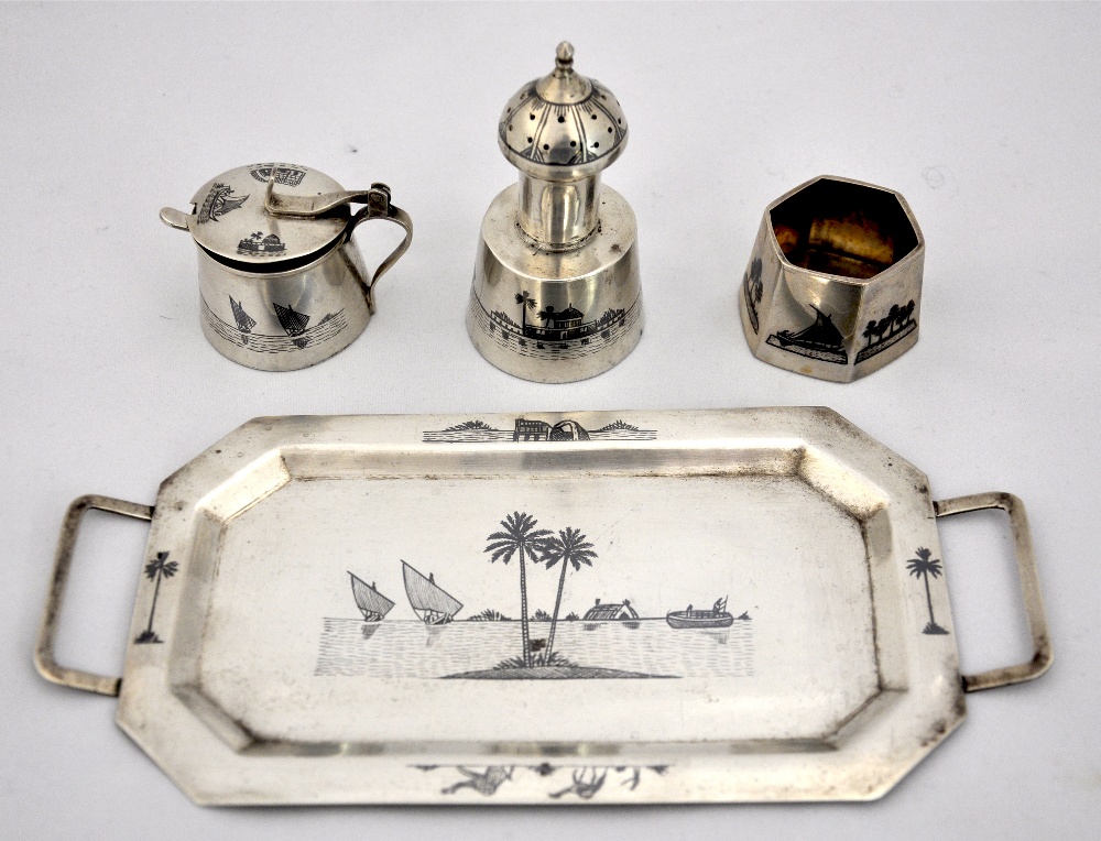 An Iraqi silver set including twin handled tray, salt, pepper and condiment pot with fine Niello