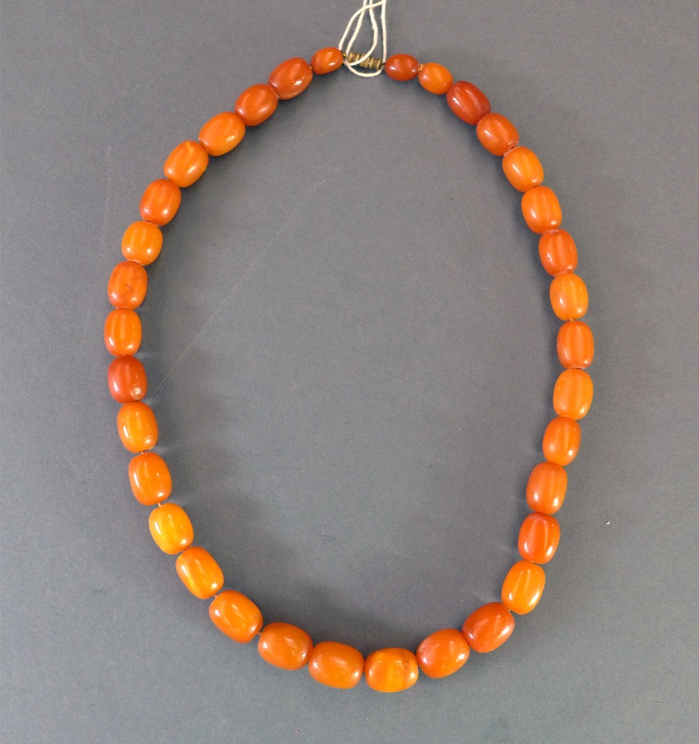 An egg yolk amber necklace consisting of 34 beads W approx 58gms