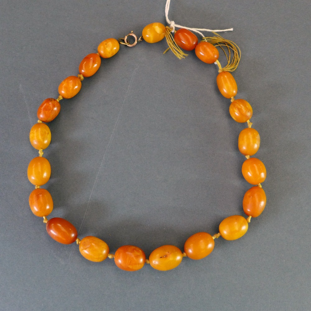 An egg yolk amber necklace consisting of 21 beads W approx 40 gms