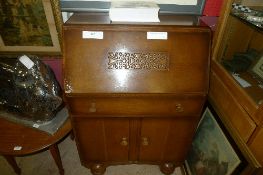 A 1930`s oak veneered fall front bureau with single drawer and cupboards and an Edwardian table W