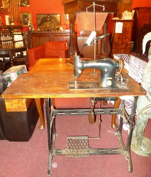An industrial Singer treadle sewing machine on cast metal supports W 107 x D 51 x H 76 cm