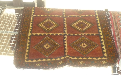 A fine old South West Persian Lori rug repeating panel motifs on a terracotta field within stylized