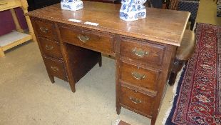 An oak kneehole desk with brass handles W 120 D 59 H 79 cm