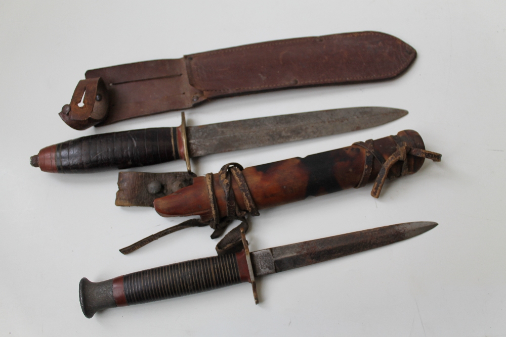 AN EARLY 20TH CENTURY `W. H. FAGAN & SON` COMBAT KNIFE, alloy pommel and brass and black layered