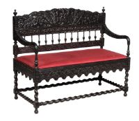An Anglo-Indian ebony sofa, second half 19th century, with overall foliate scroll carved decoration