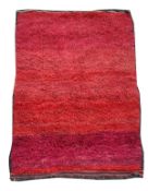 A Moroccan rug, the tufted surface in maroon and red tones, approx. 255cm x 143cm
