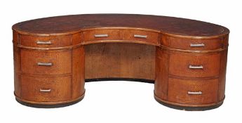 An Art Deco oak and partridge wood kidney desk, circa 1930, the shaped top with inset brown leather