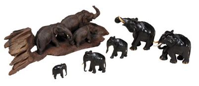 A carved and stained wood group of three elephants, 20th century, naturalistically portrayed