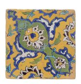 A Safavid glazed tile circa 1700, decorated with flowers and foliage in yellow, blue and green