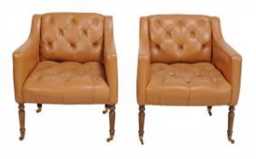 A pair of leather button back upholstered armchairs, 20th century, set on turned oak legs with