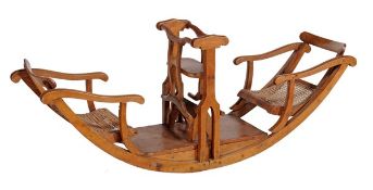 An Edwardian pine child`s rocking chair, circa 1905, in the form of a seesaw with rattan seats and