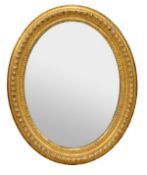 A French carved giltwood oval wall mirror in 18th century style, late 19th century, the oval plate
