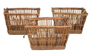 A set of three wicker and cane log baskets, 20th century, with carrying handles and on rails 59cm