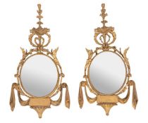 A pair of Italian giltwood oval mirrors, last quarter 18th century and later, each carved with