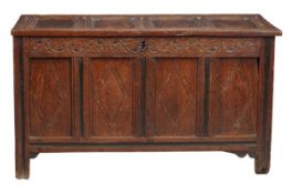 A Charles II oak coffer circa 1660 the panelled lid above a scrolled frieze and lozenge carved