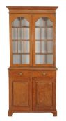 A Victorian pine bookcase, circa 1870, with moulded cornice above two glazed panel doors enclosing