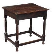 A Charles II oak side table, circa 1660, the cleated plank top above a drawer and four square and